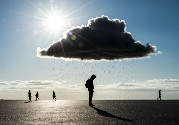 Eine Person unter einer persönlichen Regenwolke, die Opferrolle symbolisiert